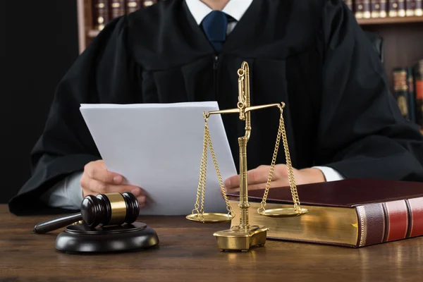 depositphotos_96530732-stock-photo-judge-reading-documents-at-desk